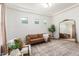 Bright living room featuring a cozy brown sofa, modern decor, and large mirror in a spacious setting at 4237 E Sierra Madre Ave, Gilbert, AZ 85296