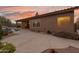 Charming backyard featuring a pool, covered patio, and desert landscaping under a vibrant sunset sky at 4413 S Tigre Del Mar Dr, Gold Canyon, AZ 85118