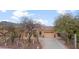 Well-maintained home exterior with desert landscaping, mature trees, and a spacious driveway at 4413 S Tigre Del Mar Dr, Gold Canyon, AZ 85118