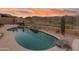 Inviting pool area with rock waterfall feature, desert landscaping, and mountain views at 4413 S Tigre Del Mar Dr, Gold Canyon, AZ 85118