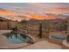 Inviting pool area with a tranquil setting, an outdoor fireplace and desert landscaping at 4413 S Tigre Del Mar Dr, Gold Canyon, AZ 85118