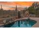 Beautiful pool area with cozy outdoor fireplace and desert landscape at 4413 S Tigre Del Mar Dr, Gold Canyon, AZ 85118