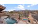 Inviting pool area with scenic mountain views and cozy outdoor fireplace for relaxing evenings at 4413 S Tigre Del Mar Dr, Gold Canyon, AZ 85118