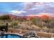 Relaxing backyard pool featuring desert landscaping and sunset mountain views at 4413 S Tigre Del Mar Dr, Gold Canyon, AZ 85118