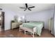 Neutral bedroom features a ceiling fan, a bench, and access to an ensuite bathroom at 4838 E Calypso Ave, Mesa, AZ 85206