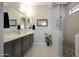 Modern bathroom featuring dual sinks, granite countertops, and a stylish walk-in shower with decorative stone at 5195 N 207Th Dr, Buckeye, AZ 85396