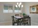 This dining area features an elegant chandelier and two windows with blinds, creating a warm and inviting ambiance at 5195 N 207Th Dr, Buckeye, AZ 85396