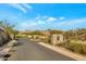 A community entrance features a stone monument, manicured landscaping, and a clear view of the surrounding desert landscape at 5195 N 207Th Dr, Buckeye, AZ 85396