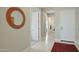 Bright hallway featuring tile flooring, a decorative mirror, and white paneled doors at 5195 N 207Th Dr, Buckeye, AZ 85396