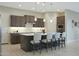 Modern kitchen featuring dark wood cabinetry, a center island with seating, and recessed lighting at 5195 N 207Th Dr, Buckeye, AZ 85396