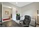 This office has a cozy daybed, an elegant chair, and a modern black desk for a functional and stylish workspace at 5195 N 207Th Dr, Buckeye, AZ 85396