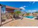 Backyard with covered seating area, swimming pool, and basketball hoop at 520 S 196Th Dr, Buckeye, AZ 85326