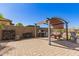 View of backyard with pergola, grill, firewood and brick pavers on sunny day at 520 S 196Th Dr, Buckeye, AZ 85326