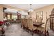 A dining room with an open floor plan showing the tile flooring and modern chandelier over the table at 520 S 196Th Dr, Buckeye, AZ 85326