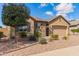 Charming home with neutral tones, a stone accent wall, desert landscaping, and an attached garage at 520 S 196Th Dr, Buckeye, AZ 85326