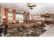 Open-concept living room featuring tile flooring, large sectional sofa, and a seamless transition to the kitchen at 520 S 196Th Dr, Buckeye, AZ 85326