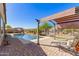 Inviting pool area with lounge chairs, shaded seating, green lawn, desert plants, and backyard fence at 520 S 196Th Dr, Buckeye, AZ 85326