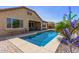 Sparkling backyard pool with comfortable patio seating, landscaping, hardscape, and blue sky at 520 S 196Th Dr, Buckeye, AZ 85326