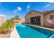 Backyard pool and patio area featuring shaded seating, a basketball hoop, and desert landscaping at 520 S 196Th Dr, Buckeye, AZ 85326