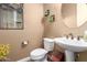 Powder room with a pedestal sink, a toilet, and decorative wall hangings at 520 S 196Th Dr, Buckeye, AZ 85326