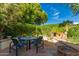 Back patio with stone pavers, lush green plants, and a circular table with four chairs at 6701 N Scottsdale Rd # 15, Scottsdale, AZ 85250