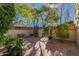 View of a private brick courtyard, featuring lush desert landscaping, wrought iron gate, and sunlit trees at 6701 N Scottsdale Rd # 15, Scottsdale, AZ 85250