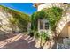Window view of a covered patio with potted plants surrounded by lush greenery and brick pavers at 6701 N Scottsdale Rd # 15, Scottsdale, AZ 85250