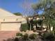 Charming home featuring a two-car garage, desert landscaping, and lovely curb appeal on a sunny day at 6701 N Scottsdale Rd # 15, Scottsdale, AZ 85250