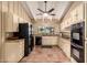 This U-shaped kitchen features terracotta tile floors, white cabinets, and black appliances at 6701 N Scottsdale Rd # 15, Scottsdale, AZ 85250