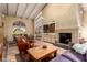 Open-concept living room with beam ceilings and a fireplace, flowing into the dining and kitchen areas at 6701 N Scottsdale Rd # 15, Scottsdale, AZ 85250