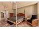 This bedroom features terracotta tile floors, wooden furniture, a ceiling fan, and a four-poster bed at 6701 N Scottsdale Rd # 15, Scottsdale, AZ 85250