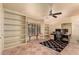 Well-lit home office featuring built-in bookshelves, a ceiling fan, and a cozy seating area by the window at 6701 N Scottsdale Rd # 15, Scottsdale, AZ 85250
