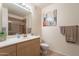 Bathroom features a single sink vanity, a framed mirror, and desert-themed wall art at 7401 W Arrowhead Clubhouse Dr # 2003, Glendale, AZ 85308