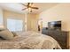 Comfortable bedroom with warm neutral tones, complemented by a ceiling fan and TV at 7401 W Arrowhead Clubhouse Dr # 2003, Glendale, AZ 85308