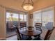 Cozy dining area with a round table, stylish lighting, and a sliding door to the balcony at 7401 W Arrowhead Clubhouse Dr # 2003, Glendale, AZ 85308