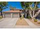 Inviting home featuring a two-car garage, desert landscaping, and lush trees for added curb appeal and shade at 7401 W Arrowhead Clubhouse Dr # 2003, Glendale, AZ 85308