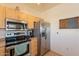 Close-up of kitchen appliances with light wood cabinets, stainless steel refrigerator, oven, and microwave at 7401 W Arrowhead Clubhouse Dr # 2003, Glendale, AZ 85308