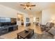 Bright living room with neutral tones, ceiling fan, TV, and view into the bedroom at 7401 W Arrowhead Clubhouse Dr # 2003, Glendale, AZ 85308