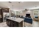 Bright, open-concept living space with a kitchen island and a view into the living and dining areas at 8445 N 61St Ln, Glendale, AZ 85302