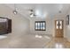 Inviting living room with carpet flooring, bright windows, ceiling fan and a wooden front door at 8544 E Ocaso Ave, Mesa, AZ 85212
