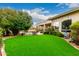 Expansive backyard featuring lush artificial turf, mature trees, pool, and covered patio, ideal for outdoor enjoyment at 8607 E Preserve Way, Scottsdale, AZ 85266