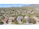 Aerial view showcases neighborhood with tile roofs, desert landscaping, and mountain backdrop at 10468 E Raintree Dr, Scottsdale, AZ 85255