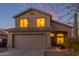 Charming two-story home featuring a two-car garage and desert landscaping at dusk at 10468 E Raintree Dr, Scottsdale, AZ 85255