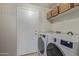 The laundry room offers modern appliances, shelving, and a convenient adjacent door at 10468 E Raintree Dr, Scottsdale, AZ 85255