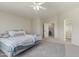 Spacious main bedroom featuring neutral tones, a ceiling fan, and a view into the main bathroom at 10468 E Raintree Dr, Scottsdale, AZ 85255