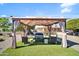 Backyard featuring a furnished gazebo on an artificial grass area and rock landscape at 10842 W Sarabande Cir, Sun City, AZ 85351