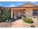 Inviting covered porch with decorative arch, desert landscaping, and flagstone walkway at 10842 W Sarabande Cir, Sun City, AZ 85351