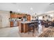 Spacious open kitchen featuring wood cabinets, an island with seating, and seamless flow to the living area at 10842 W Sarabande Cir, Sun City, AZ 85351