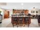 Kitchen island with seating features wood cabinets, tile floor, and recessed lighting at 10842 W Sarabande Cir, Sun City, AZ 85351