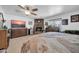 Bedroom with a brick fireplace, TV, ceiling fan and dresser at 10842 W Sarabande Cir, Sun City, AZ 85351